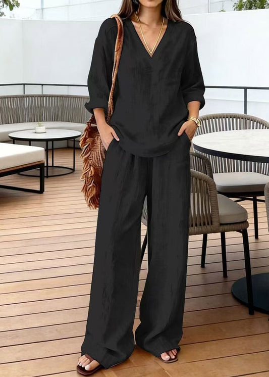 Conjunto de dos piezas: blusa negra sencilla con cuello en V y detalle de parches, y pantalones de pierna ancha con manga corta